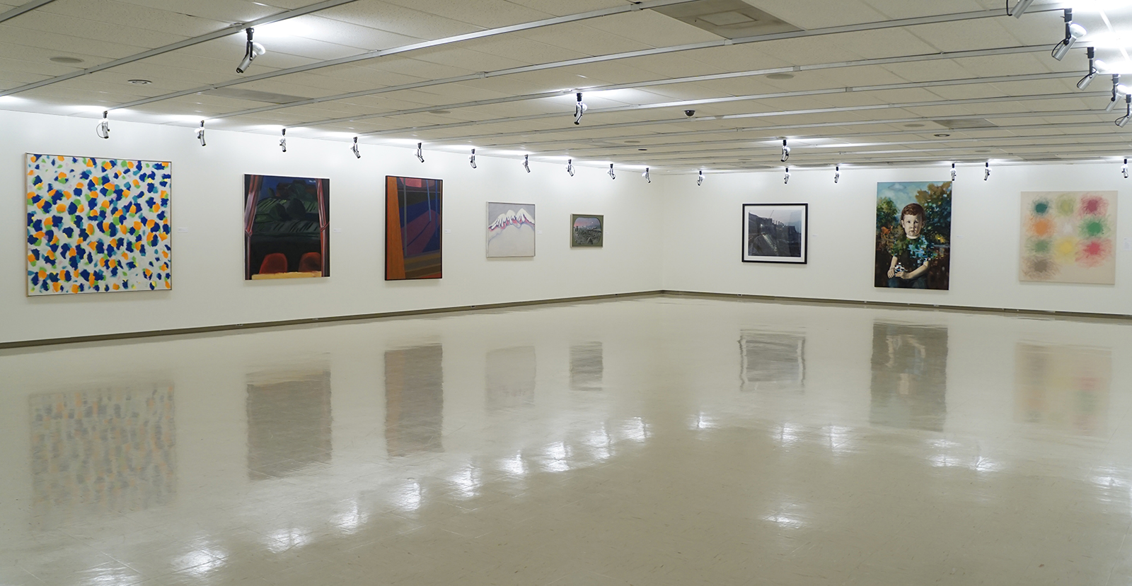 In a gallery, eight large paintings line two walls.
